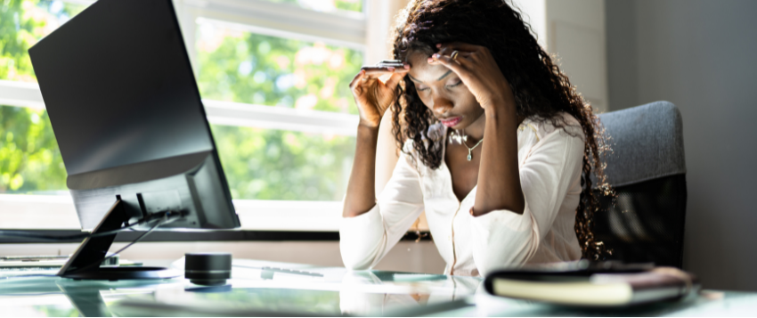 woman holding her head in her hands looking at the table